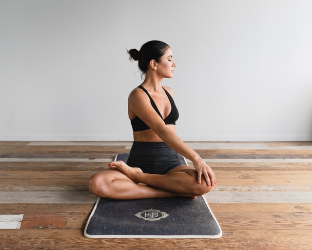 woman stretching on yoga mat, new to working out, a beginner learning how to exercise