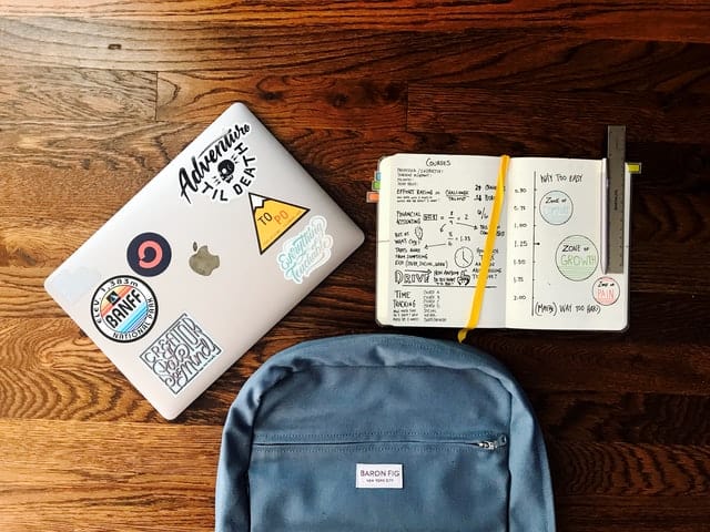backpack, laptop, and notebook on the floor