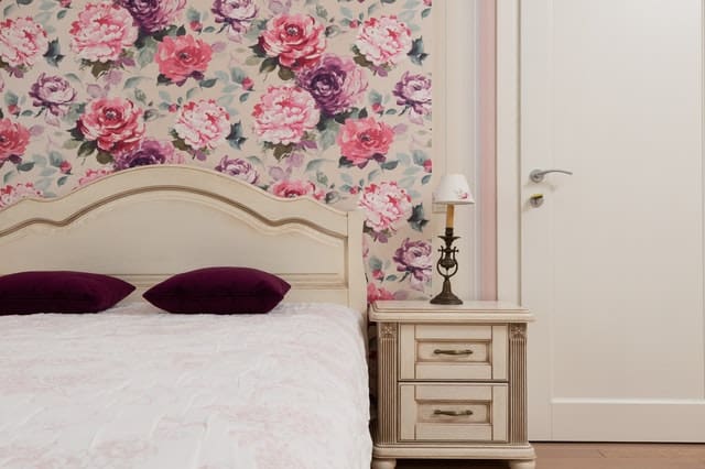 pink bedroom with floral wallpaper and bed