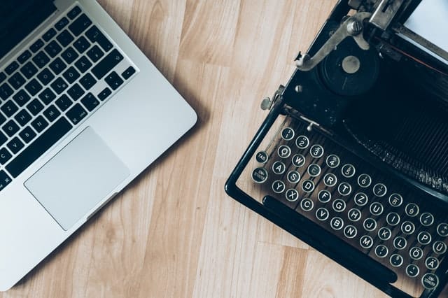 laptop and typewriter next to each other