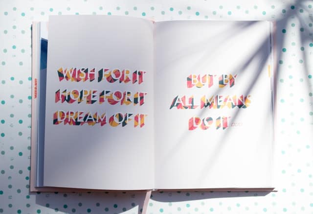 notebook with rainbow text that reads "wish for it, hope for it, dream of it, but by all means, do it."