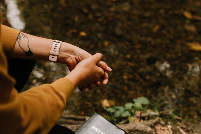 hands folded over a bible outside