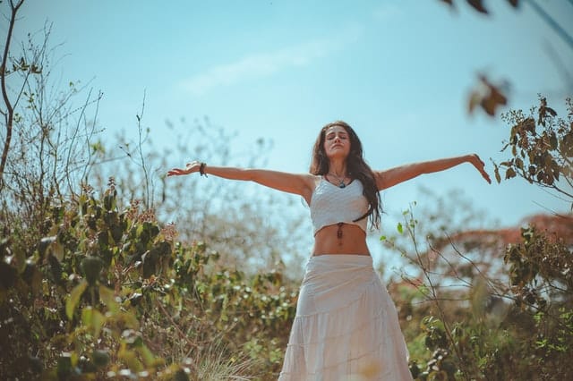 girl in skirt outside with arms outstreatched