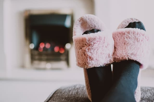 propped up feet with black socks and pink slippers