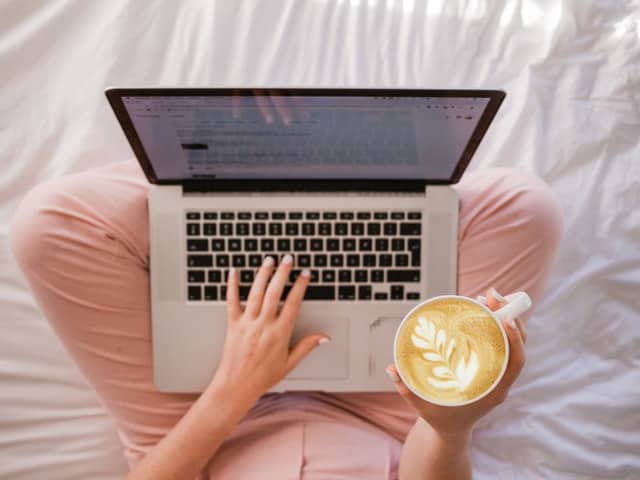 girl with laptop in lap and coffee searching for a better job
